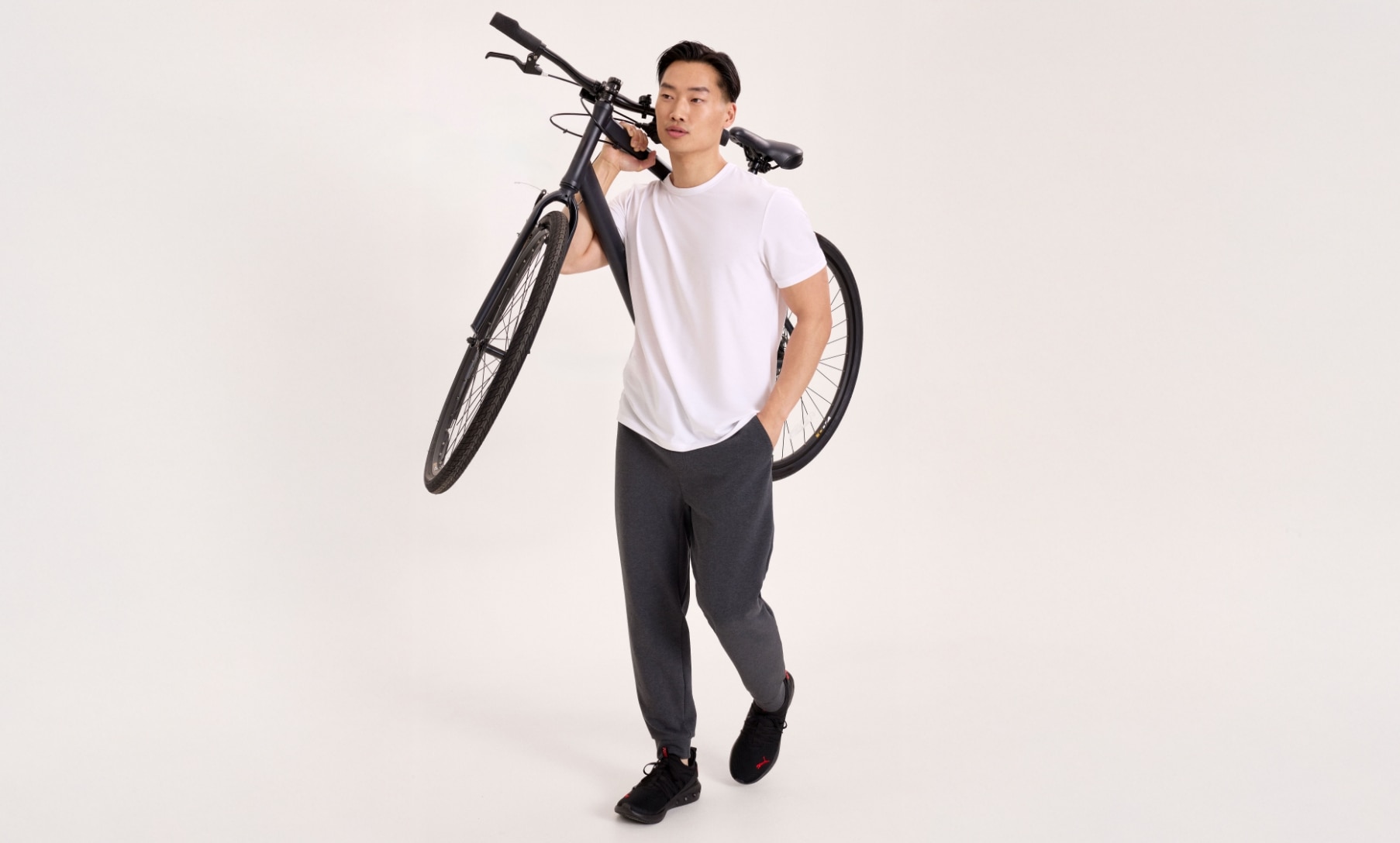 Man holding a bike wearing Denver Hayes Performance clothing.